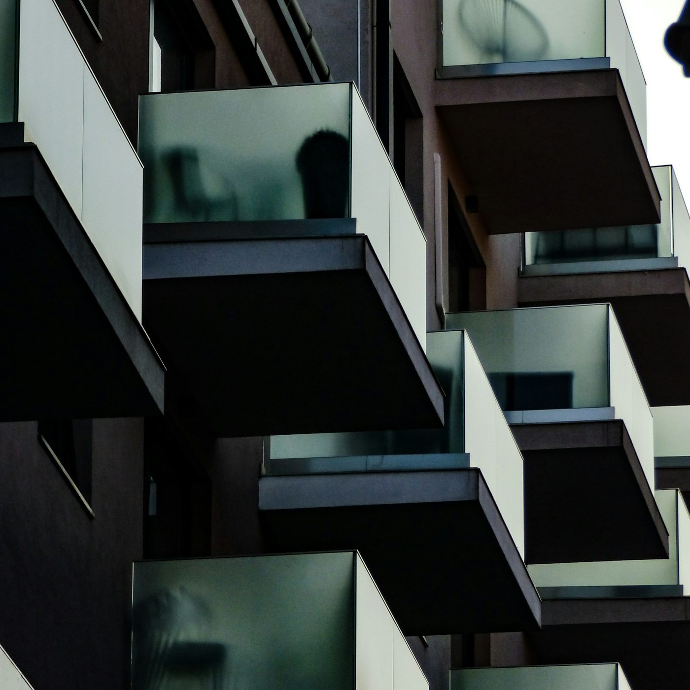 Detalle de balcones con paneles translúcidos y perfiles oscuros