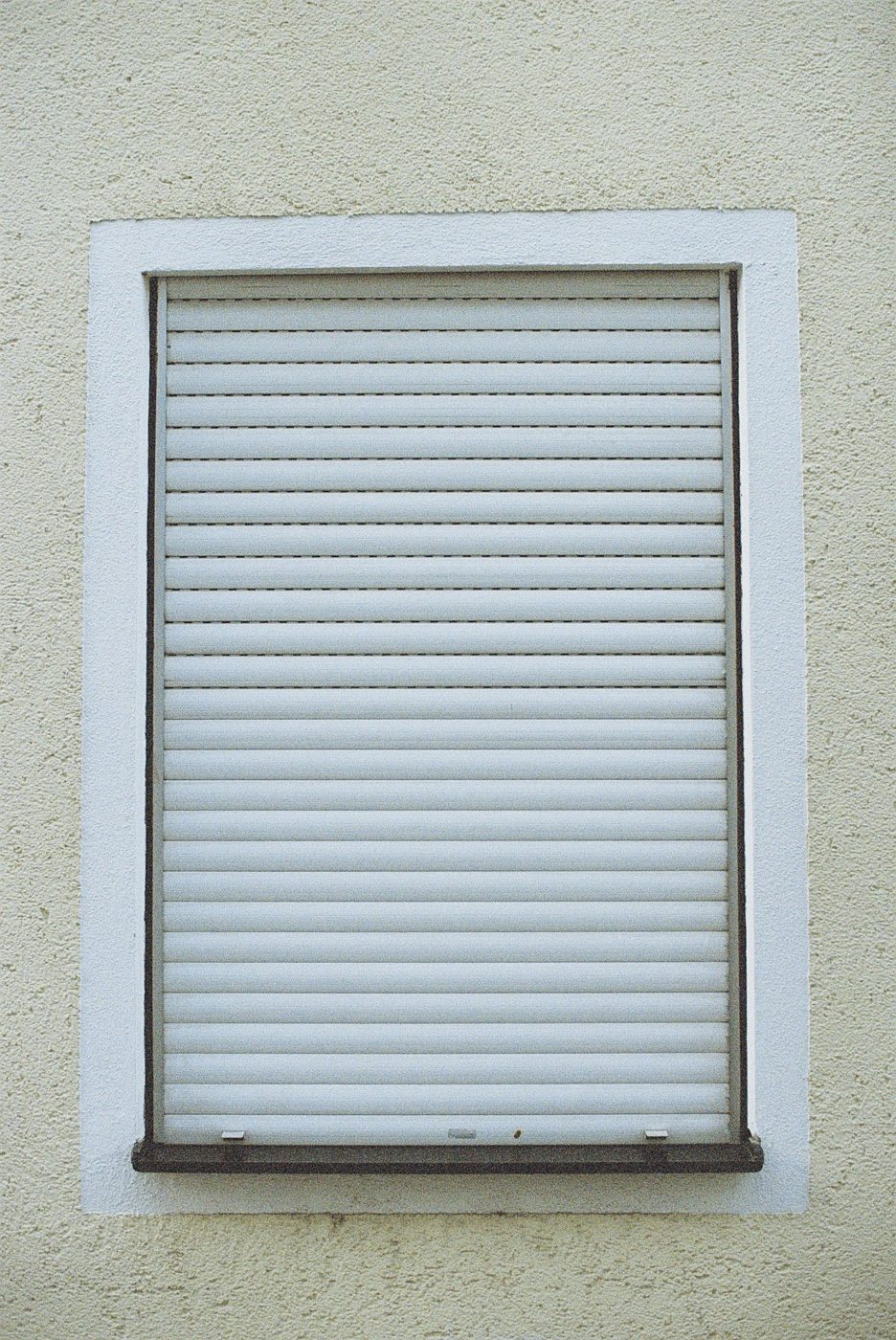 Persiana enrollable cerrada en una ventana de vivienda