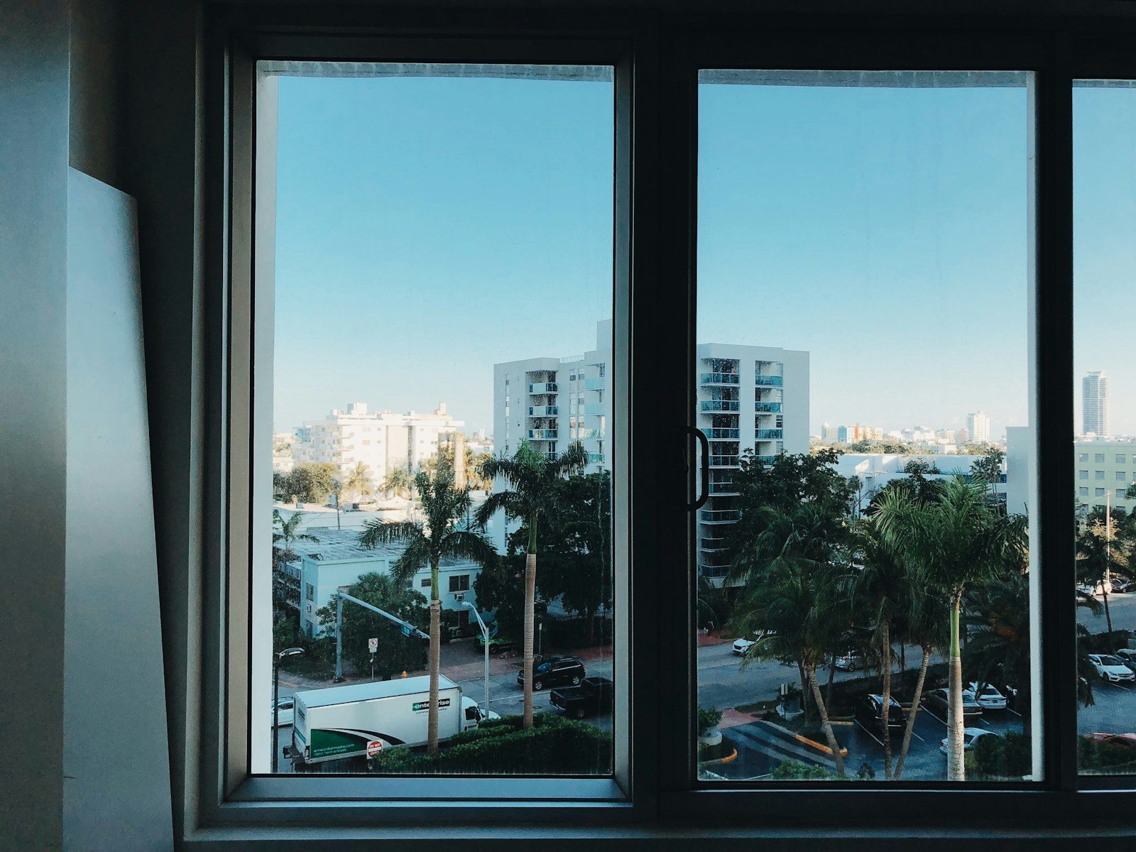Ventana de dos hojas con marco oscuro y vistas urbanas